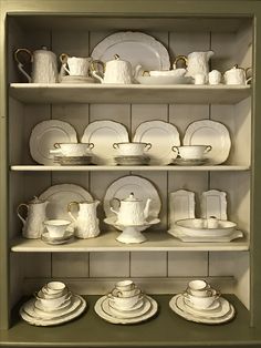 the shelves are filled with dishes and cups