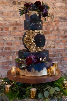 a three tiered cake decorated with flowers and greenery