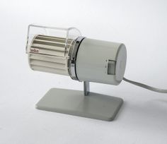 a white electric fan sitting on top of a metal stand