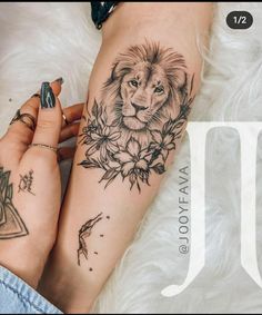 a woman's leg with a lion and flowers tattoo on the side of her thigh