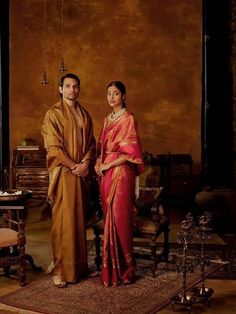 a man and woman standing next to each other in front of a painting on the wall