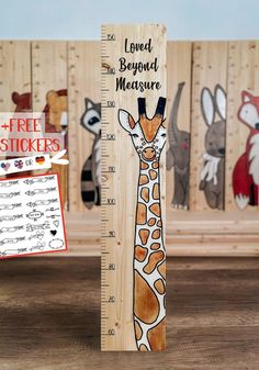 a tall wooden growth ruler with an image of a giraffe on it's side