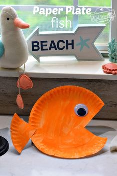 an orange paper plate fish next to a window sill