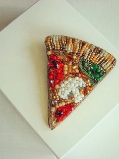 a piece of food that is on top of a white surface with beads and other things