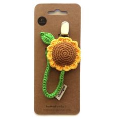 a crocheted sunflower is attached to a cell phone case with a lanyard