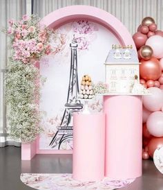 a pink party with balloons and decorations on the floor, in front of a eiffel tower backdrop