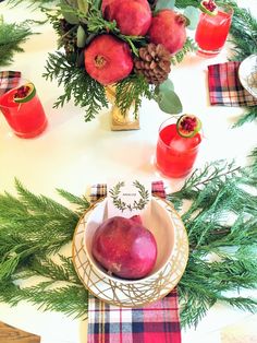 the table is set with pomegranates and pine branches