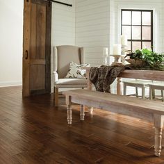 a wooden table sitting next to a white chair on top of a hard wood floor