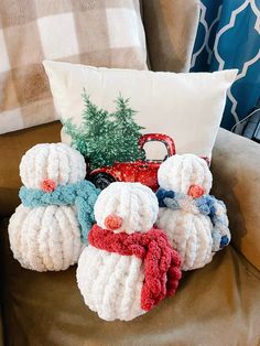 crocheted snowmen sitting on a chair with a pillow