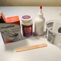 the ingredients to make an ice cream cake are displayed on a white counter top with a wooden spatula next to it