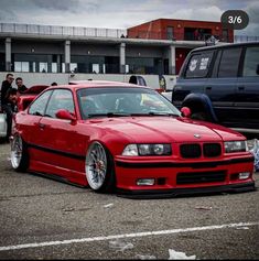 a red car parked in a parking lot next to other cars