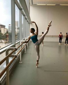 ballet students practicing in an empty room with large windows