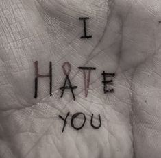 i hate you written on the palm of someone's hand with red writing in it