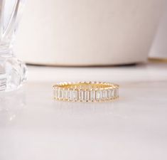 a gold ring with baguettes sits on a table