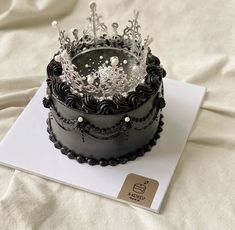 there is a black cake with a crown on top