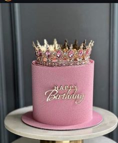 a pink birthday cake with a crown on top