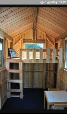 the inside of a tiny house with wooden walls and windows, built into the ceiling