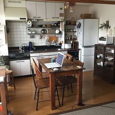 a kitchen filled with lots of appliances and furniture next to a dining room table in front of a stove top oven