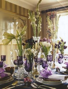 the table is set with purple and white flowers