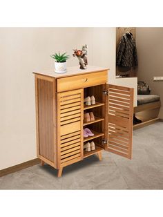 a wooden shoe cabinet with open doors on the front and bottom shelves, next to a small potted plant