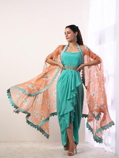 Our custom 'Sakura' print is thoroughly inspired by the overwhelming beauty of the elusive pink flower on the Japanese geometrical patterns bringing together the Japanese and Indian culture. Featuring a teal draped dress with an embroidered belt. It is paired with a printed coral silk organza cape enhanced with color block details. Perfect for destination beach wedding party or bridesmaid outfits! Fabric Composition: Crepe, Organza Care Instruction: Dry Clean Only. Do not use heavy Iron Draped Dress Indian, Green Spring Dress With Traditional Drape, Green Traditional Drape Dress For Spring, Summer Dresses With Draped Sleeves Traditional Drape, Festive Multicolor Draped Dress, Festive Green Draped Dresses, Floral Print Dress With Traditional Drape For Party, Fitted Dress With Digital Print And Traditional Drape, Bohemian Dress With Floral Print And Traditional Drape