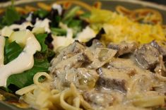 a plate with pasta, meat and vegetables on it