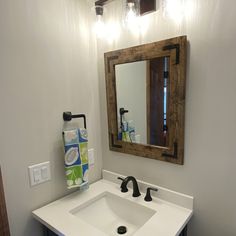 a bathroom with a sink, mirror and towel rack on the wall above it's counter