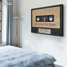 a bedroom with a bed and an old fashioned audio tape wall hanging on the wall