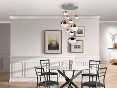 a dining room table with four chairs and pictures on the wall above it in an empty room