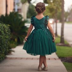 Fit for a princess, this dress has it all. Soft emerald satin graced with a touch of lace, this dress is a showstopper! Sleeves are embellished with whimsical die cut flowers that will have all eyes on her. Tulling overlay skirt adds just the right touch of fullness and twirl. Fully lined with soft cotton, back zip. 100% poly self, 100% cotton lining. Machine wash, hang dry.