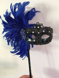 Feather mask on a stick- Mask for Eye Glasses- NYC Masked ball- New Years Eve- Masquerade Ball- Mardi Gras Mask -Halloween- Holiday party- Music mask Hello, Perfect for a masquerade party, birthday celebration, costume party, New years eve celebration, or Mardi Gras. This feathers are on the side and a matching ribbon covered stick. A beautiful brooch sets it all off! The feathers are about 8 inches. Feather colors: Royal Green Hot pink White Black Pastel multi Red Green Mask colors: A) solid go Mascarade Wedding, Blue Masquerade Mask, Masquerade Mask Diy, New Years Eve Celebration, Masquerade Ball Party, Green Mask, Black Pastel, Feather Mask