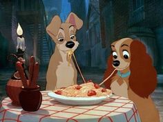 the lady and the tramp are eating spaghetti together in front of two dogs sitting at a table