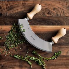 a knife and some herbs on a cutting board