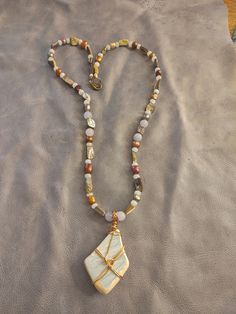 This necklace features a beautiful shard of surf tumbled pottery found on a beach in Puerto Rico. It is wrapped in brass colored copper wire. The beads are AAA quality aquamarine, abalone shell and dyed freshwater pearls. Elegant Beach Jewelry With Gemstone Beads, Nature-inspired White Necklace With Natural Stones, Bohemian Long Crystal Necklace For Beach, Elegant Wire Wrapped Necklaces, Bohemian Shell Necklace With Gemstone Beads, Beach Style Amulet Pendant Jewelry, White Artisan Gemstone Necklace, Artisan White Gemstone Necklace, White Gemstone Artisan Necklace