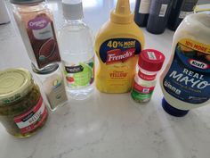 several different types of condiments on a counter top, including mayonnaise and seasoning