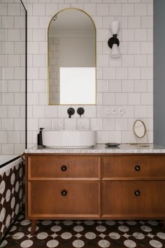 a bathroom with a sink, mirror and tiled walls in the background is a bathtub