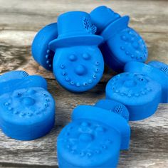 several blue plastic objects sitting on top of a wooden table next to each other with holes in them