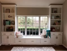 a window seat in the corner of a room with built - in bookshelves