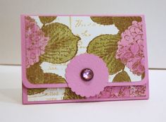 a close up of a pink and gold card with a flower on the front side