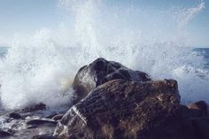 an ocean wave hitting on rocks in the water