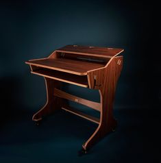 a wooden desk sitting on top of a black floor