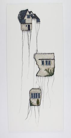 three houses hanging from strings in front of a white wall