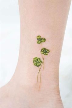 four leaf clover tattoo on the ankle, with green leaves growing out of it's sides