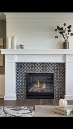 a living room with a fire place in the center and white furniture on the other side