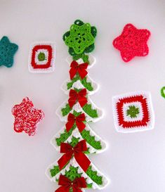 crocheted christmas tree decorations are displayed on a white surface with green and red accents