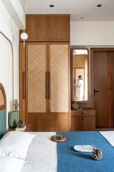 a bedroom with a bed, dresser and mirror in the corner next to wooden closets