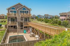 a house that is on the side of a hill with a pool in front of it