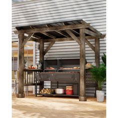 an outdoor bbq with grilling area and potted plants on the deck next to it