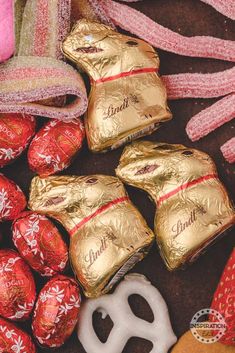 some chocolates are laying on the ground next to pink ribbons and other holiday decorations