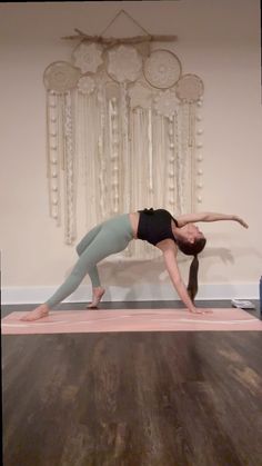 a woman is doing yoga in front of a wall